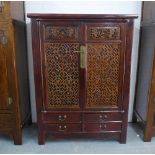 Chinese hardwood cabinet with stylised fretwork panelled doors, shelved interior with two internal