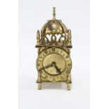 A small Smiths brass mantle clock, lantern style with domed to and chapter ring with roman numerals,