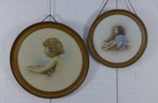 Two early 20th century prints of young children, contained with circular glazed frames, larger