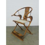 Chinese Ming style elm folding armchair, horseshoe back and foliate pierced splat with woven seat,