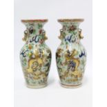 Pair of Chinese celadon ground vases shishi in low relief, in underglaze blue surrounded by