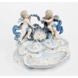 A rococo style porcelain inkwell with cherubs and ribbon garlands, 14 x 21cm.