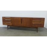 A H Mackintosh sideboard with a pair of cupboard doors flanked by three drawers, on tapering legs,