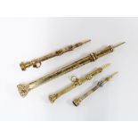 Four Victorian yellow metal propelling pencils, each with a coloured hardstone terminal, two with