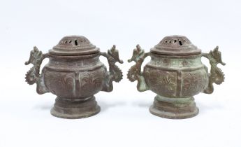 A pair of Chinese archaic style bronze censors, twin handled with pierced covers, 14cm (2)