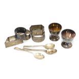 A collection of silver napkin rings, an egg cup and a teaspoon, mixed hallmarks (a lot)