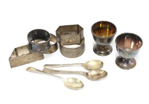 A collection of silver napkin rings, an egg cup and a teaspoon, mixed hallmarks (a lot)