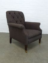 A modern button back armchair, upholstered in dark brown tweed style fabric, on mahogany legs with