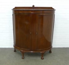 Mahogany bow front cabinet, the shaped top with gadrooned edge over two plain doors, opening to