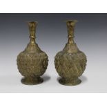 A pair of Nigerian bronze vases with prunt decoration, on circular footrims 23cm (2)