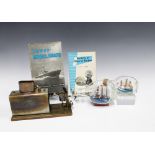 Two model ships in bottles, together with a model boat steam engine and the books 'Secrets of