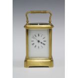 A small brass and glass panelled carriage clock (one glass side panel lacking) , full striking, with