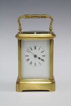 A small brass and glass panelled carriage clock (one glass side panel lacking) , full striking, with