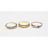 Two 18ct gold dress rings and a yellow metal ring (3)