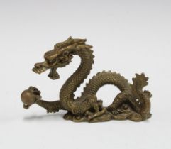 A bronze dragon and pearl of wisdom figure, 12cm long