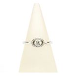 18ct white gold diamond ring with a claw set bright cut diamond within a surround of smaller