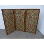 Mahogany three fold screen with floral upholstered panels, 218 x 153cm.