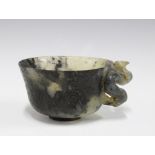 Chinese carved hardstone cup with a dragon handle, standing on a plain circular footrim, 12cm
