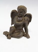 Bronze patinated metal figure of a seated cherub, 13cm