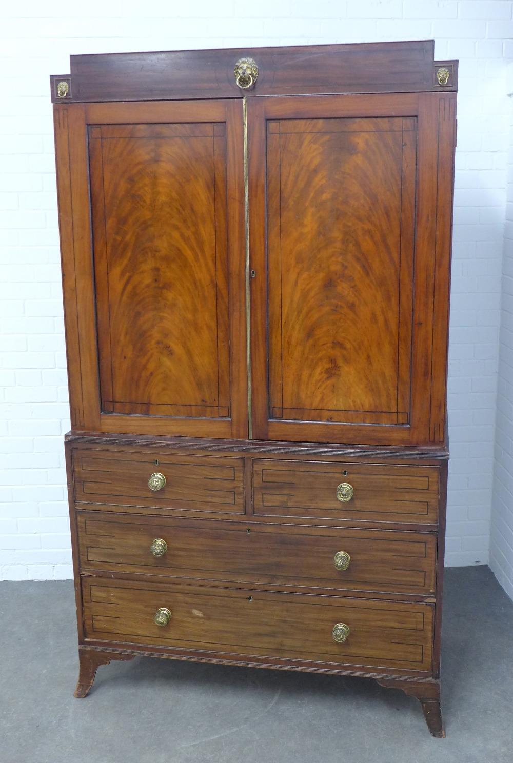 Georgian mahogany linen press, stepped pediment above a pair of flame veneered doors, internal brass