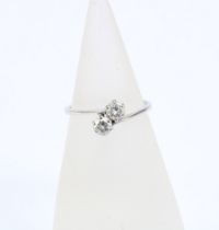 Diamond two stone crossover ring, set in an unmarked white metal band