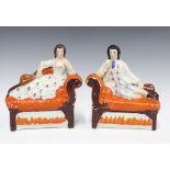 A pair of 19th century Staffordshire musician figures, each modelled reclining on a chaise longue,