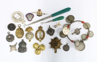 A collection of military cap badges and buttons, a coin bracelet and button hooks, etc