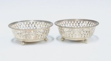George V silver bonbon dishes, circular with pierced sides, raised on three bun feet, Birmingham