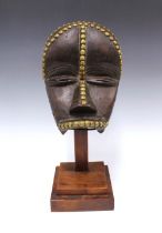 Dan Mask, Liberia, wooden with brass studwork, on a display plinth, 26cm. Private collection,