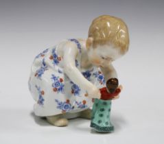 Meissen porcelain figure of a child playing with a doll from the series "Hentschel children".