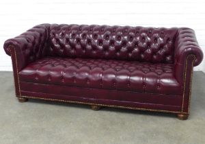Leather chesterfield sofa, with brass studs and bun feet, 197 x 72 x 57cm.
