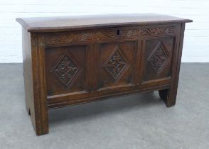 An oak blanket box, plain rectangular top opening to a void interior, with carved frieze and