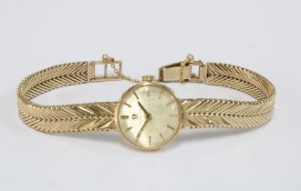 9ct gold Ladies Omega wrist watch, champagne dial with hour baton markers, on a textured 9ct gold