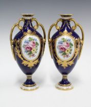 Pair of Royal Crown Derby urn vases, blue ground and floral decorated panels, printed factory