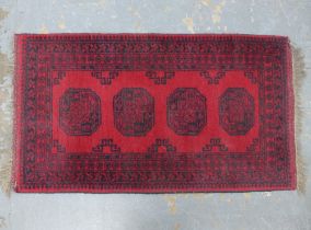 Afghan rug, red field with four guls, 140 x 76cm.