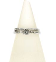 A platinum and diamond ring with a claw set central bright cut diamond flanked by a baguette diamond