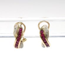 A pair of 9ct gold ruby and diamond earrings with a row of eight calibre cut rubies flanked by white