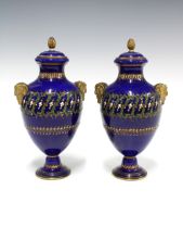 A pair of Sevres porcelain vases, the rich blue ground painted with jewelled enamels with gilded