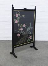 An ebonised fire screen with peacock panel, 59 x 96cm.