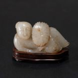 A CHINESE WHITE JADE 'BOY AND LOTUS' ORNAMENT