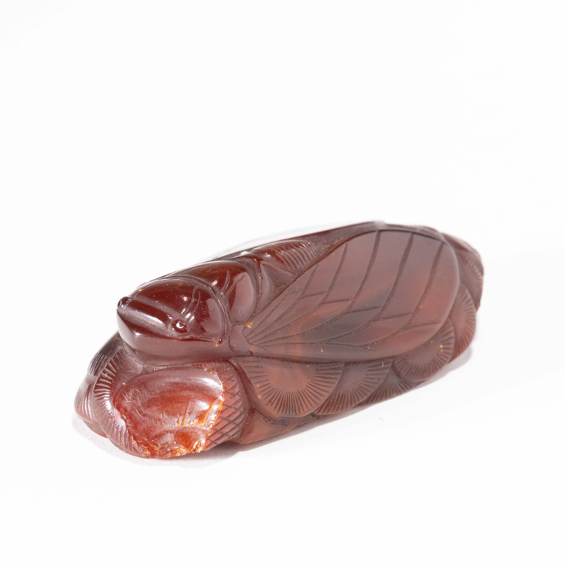 A CHINESE AMBER CICADA-FORM ORNAMENT