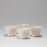 A SET OF FOUR BLANC-DE-CHINE 'PLUM BLOSSOM' CUPS