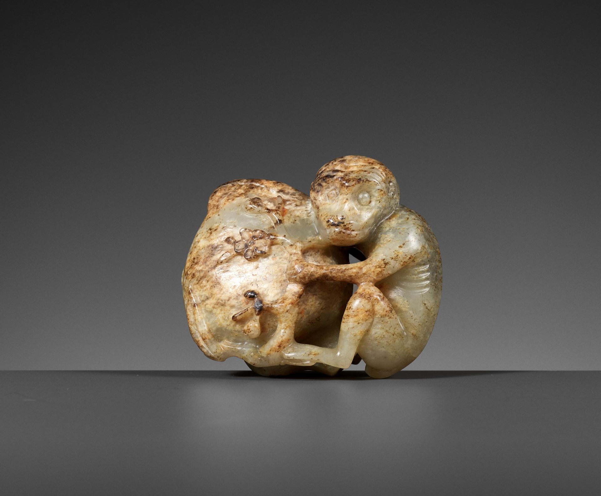A MOTTLED PALE CELADON JADE 'MONKEY AND PEACH' FIGURE, 17TH - 18TH CENTURY