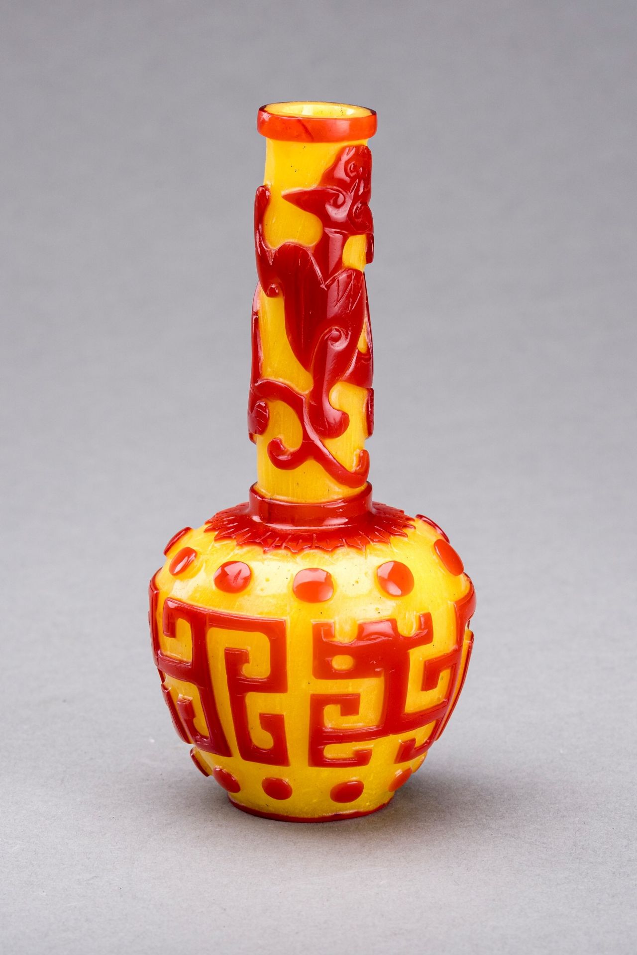 A CARVED RED-OVERLAY YELLOW GLASS BOTTLE VASE, QIANLONG MARK AND PERIOD