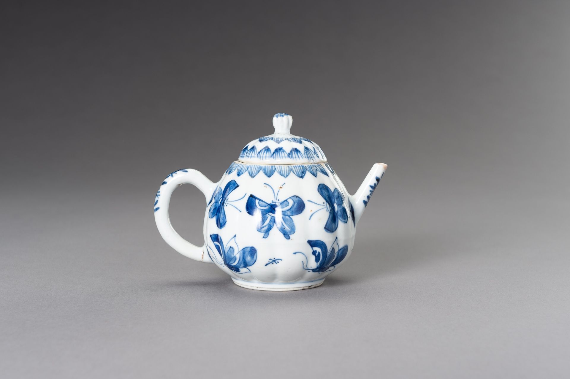 A BLUE AND WHITE 'BUTTERFLIES' TEAPOT, QING - Image 7 of 9