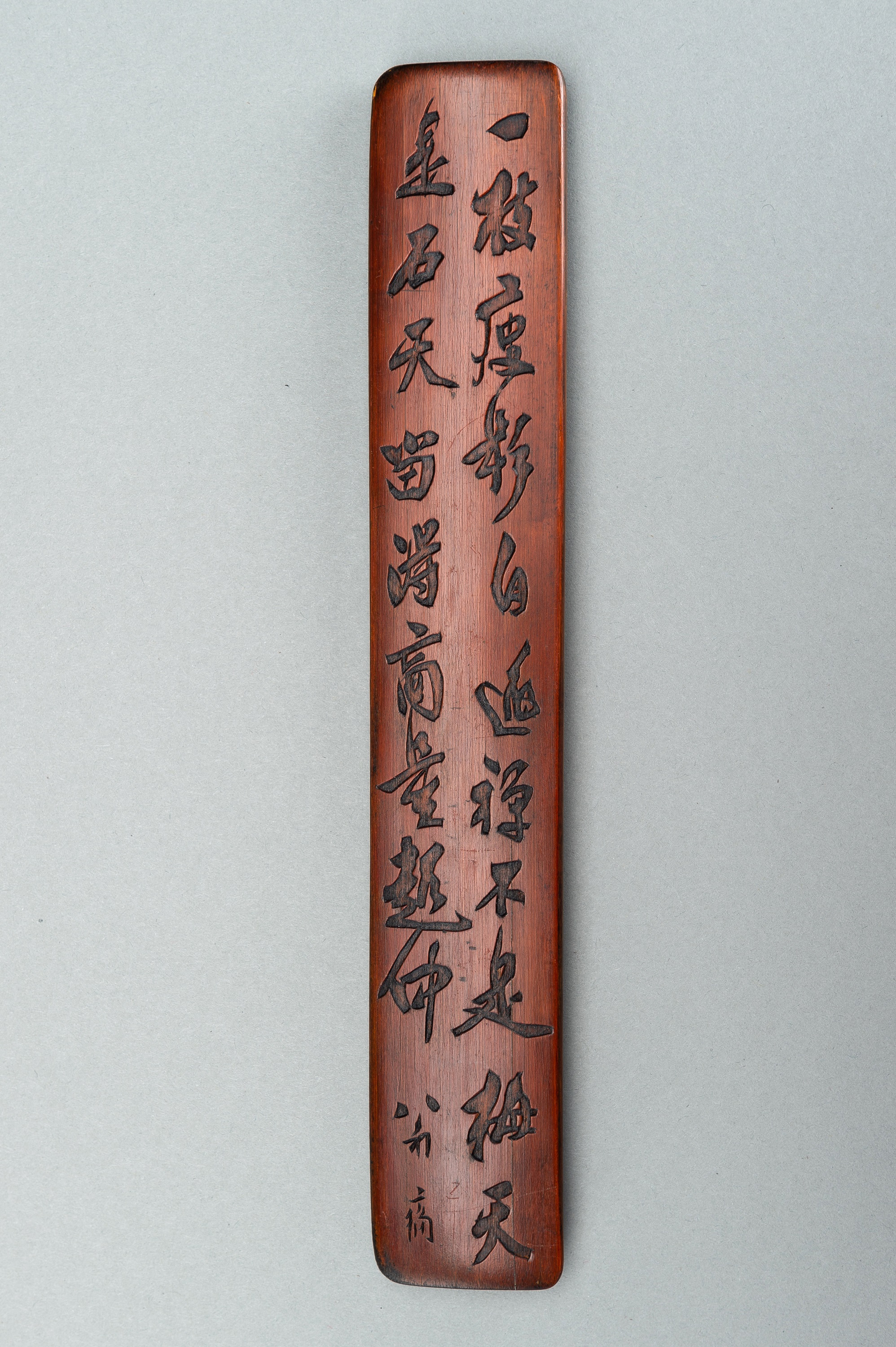 A BAMBOO WRIST REST WITH CALIGRAPHY