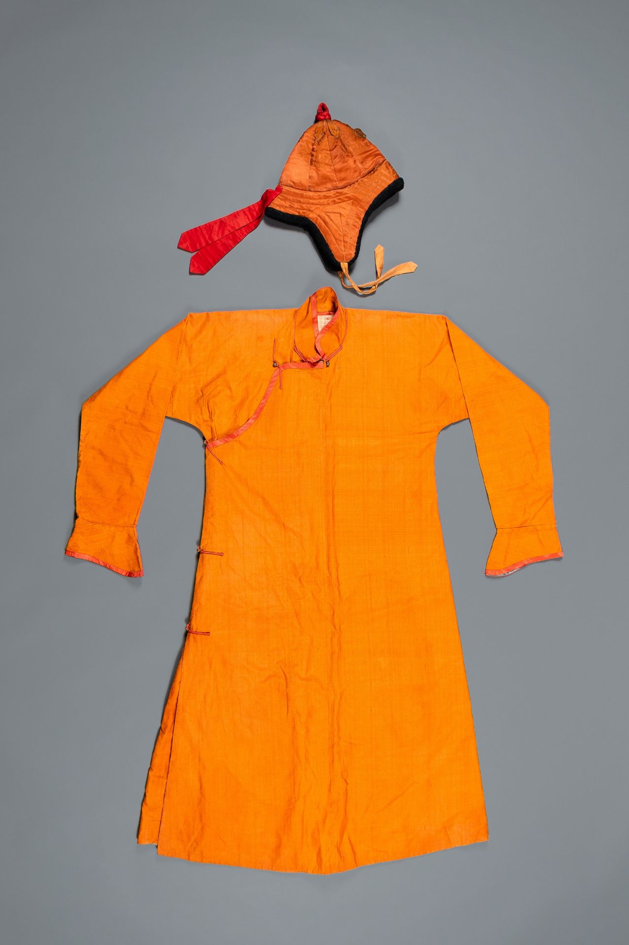 AN ORANGE TRADITIONAL ROBE, CHUBA, AND A HAT