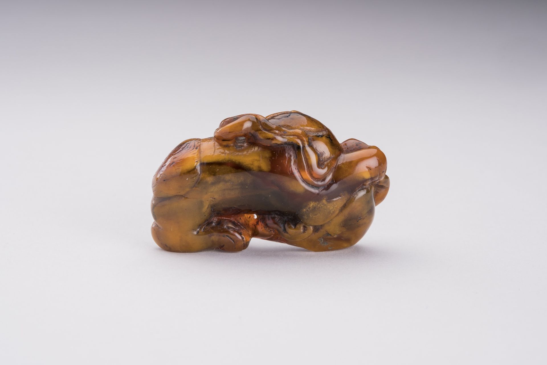 A RARE AMBER CARVING OF A BUDDHIST LION WITH BALL - Bild 6 aus 6