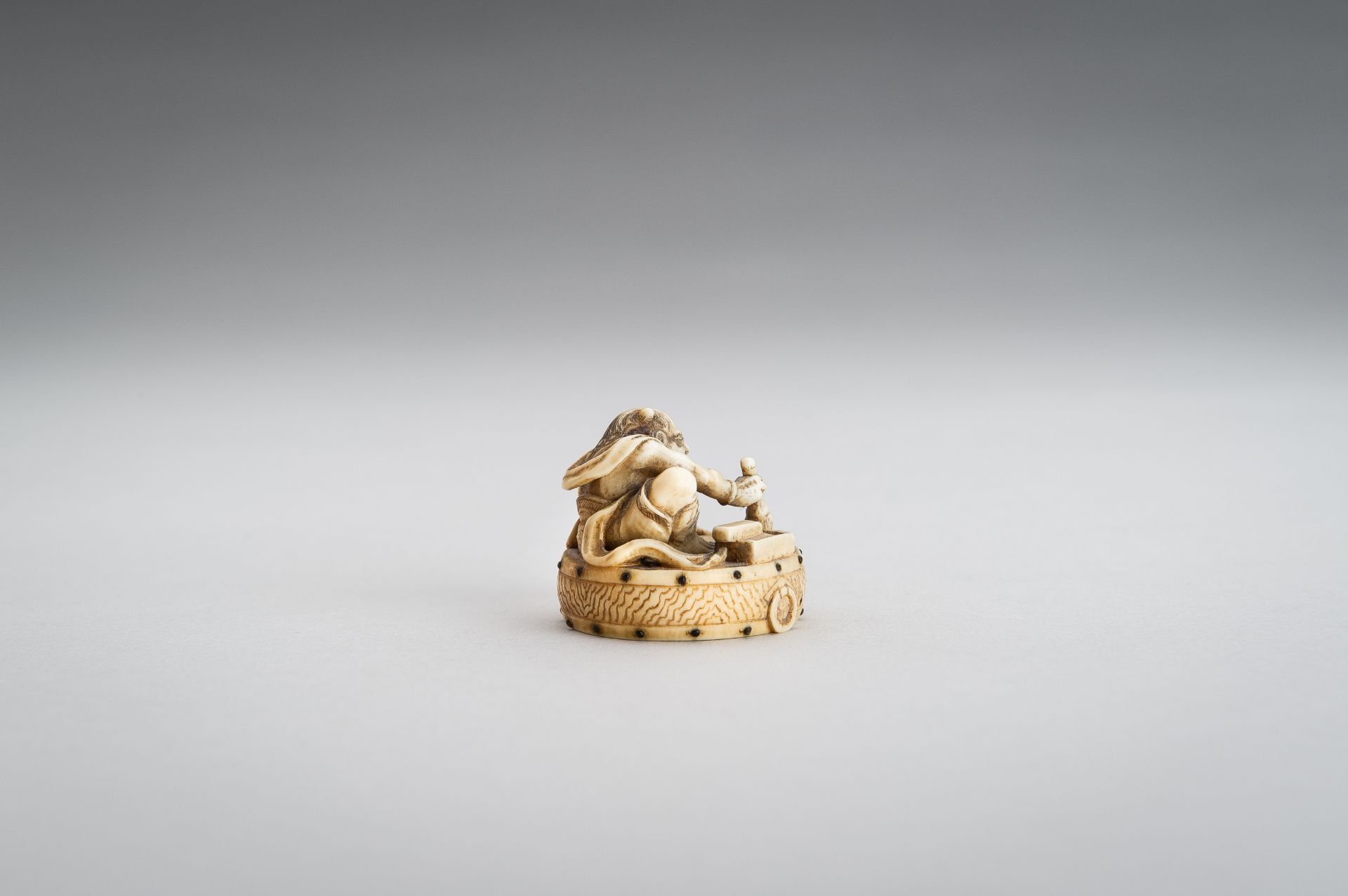 GYOKUSHU: AN IVORY NETSUKE OF AN ONI CLEANING A DRUM - Image 7 of 12