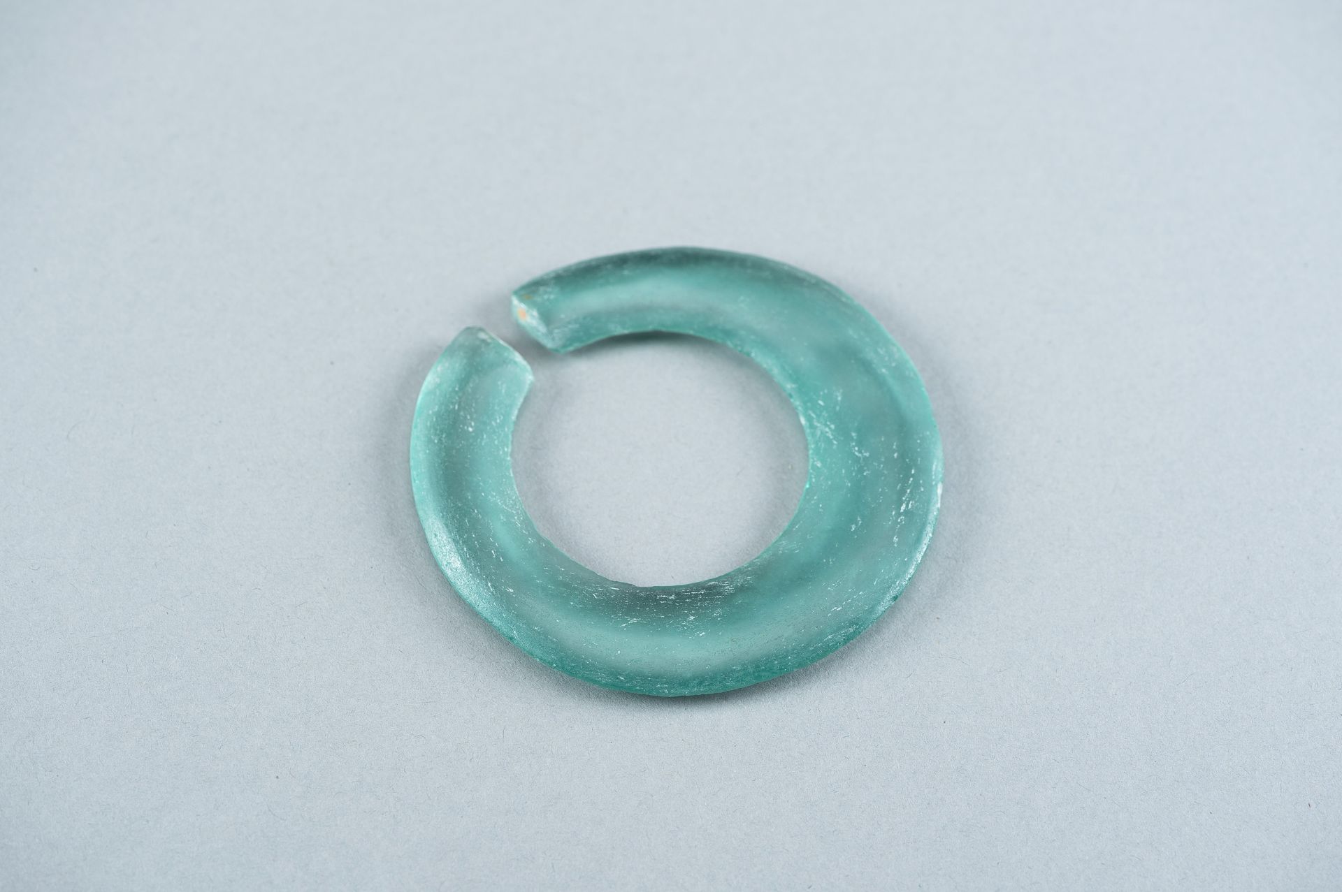 AN ARCHAIC PALE GREEN GLASS DISC - Image 6 of 9